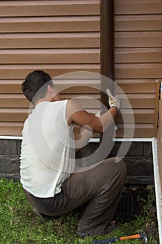 Man sets drainpipe on the wall