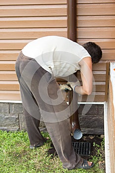 Man sets drainpipe on the wall