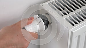 The man sets the radiator thermostat to the maximum mode