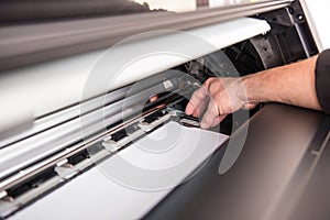 Man setting the printer to the width of the paper