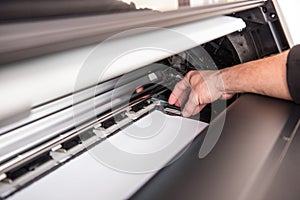 Man setting the printer to the width of the paper photo
