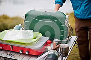 Man setting up a camping gas stove outdoors