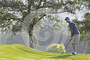 Man setting up golf shot - Horizontal