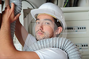 Man setting up ventilation system indoors