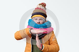 Man in several winter hats and scarfs making time out gesture. I need to stop.