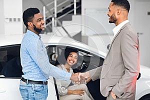 Man Shaking Hands With Car Sales Manager In Dealership Store