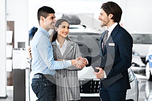 Man Shaking Hands With Car Sales Manager In Dealership Store