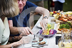 Man sharing food to woman at backyard barbecue party