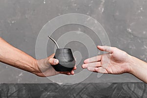 A man sharing Yerba Mate tea in gourd with sipped metal straw