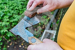A man is sharpening an ax with a grindstone photo