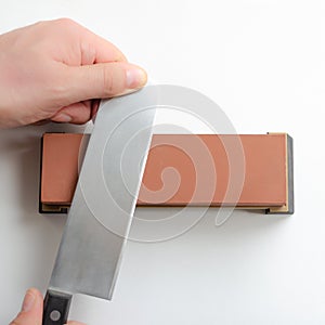 Man sharpening a Japanese Nakiri knife with whetstone sharpener