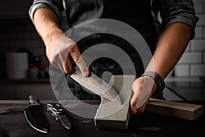 Man sharpening a knife with sharpen stone tool