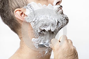 Man shaves his beard with a razor