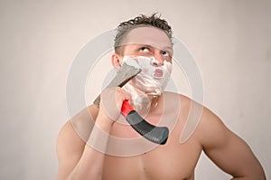 Man is shaving by axe.