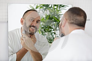 Man shaving in bathroom