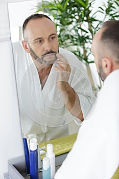 man shaving in bathroom