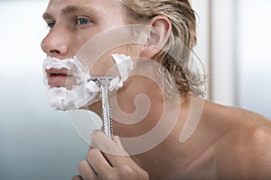 Man Shaving In Bathroom