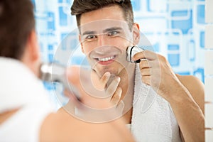 Man shaving with electric shaver