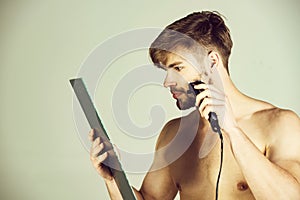 Man shaving face with shaver, razor or beard trimmer