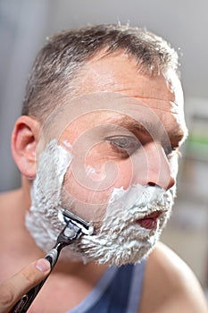 Man shaving himself with a razor