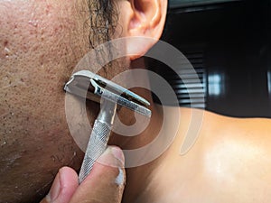 Man shaving his beard in the bathroom.