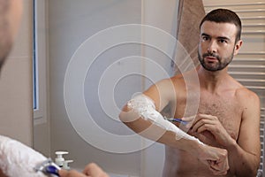 Man shaving his hairy forearms