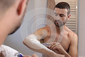 Man shaving his hairy forearms