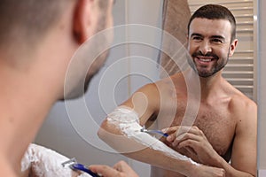 Man shaving his hairy forearms