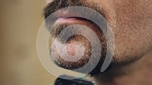 Man shaving thick graying beard off, changing his personal style, face closeup