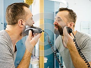 Man shaving trimming his beard