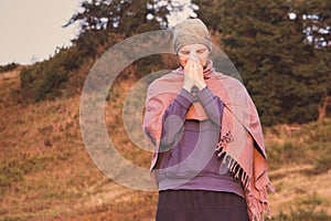 Man in shawl with namaste hands praying in mountains. Sunrise praying concept. Morning meditation on nature background.