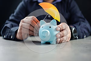 Man sheltering piggy bank with umbrella. Risk insurance in banking