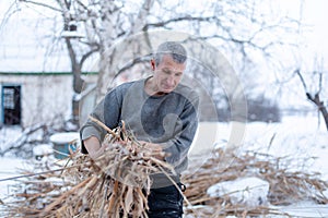 A man shelters a dry reed field, heats plants in winter