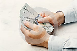 Man in shirt holding dollar money in his hands. Economy, saving, trade, salary and donate concept.