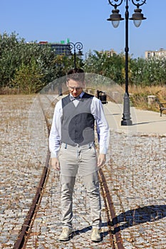 Man in shirt and vest with bow tie and glasses, standing in line