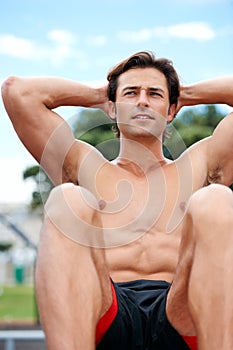 Man, shirtless and sit ups for fitness, exercise and workout outdoors, muscle and crunches or cardio for health. Male