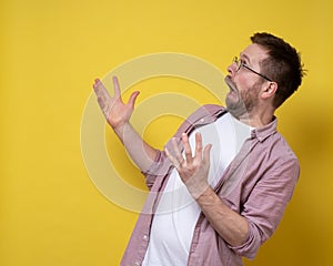 Man in shock and stupor, looks to the side with an open mouth and a strange grimace and makes an inquiring gesture with