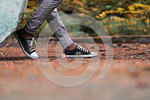 Man shoes canvas outdoor, leg man wear black and white sneakers canvas shoes and jean trouser.with copy space for text stylish
