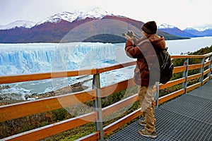Man Shooting Photos of Perito Moreno Glacier from the Boardwalk in the Los Glaciares National Park, El Calafate, Argentina photo