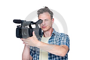 Man shoots a video with a professional camcorder, isolated on white background