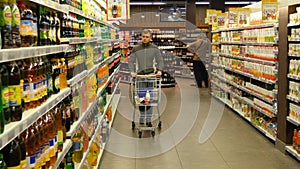 Man with shopping cart walking in the hypermarket