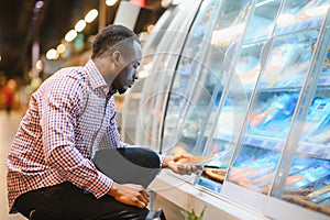 Man shopping for fish seafood in supermarket retail store