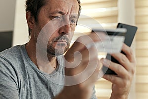 Man shopping online from home with mobile phone and credit card