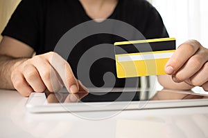 Man holding tablet pc and credit card indoor, Shopping online photo