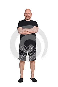 Man in short pant pajamas on white background, arms crossed