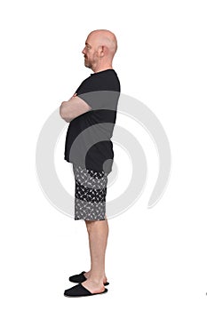 Man in short pant pajamas on white background, arms crossed, profile