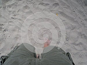 Man in shorts walking barefeet on the sand