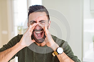 Man shouting with rage covering mouth with hands, yelling frustrated and crazy