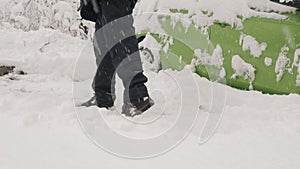 Man with shovel clears snow around the car after a winter storm, close-up.