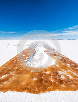 Man shovel sault banks in Salar de Uyuni